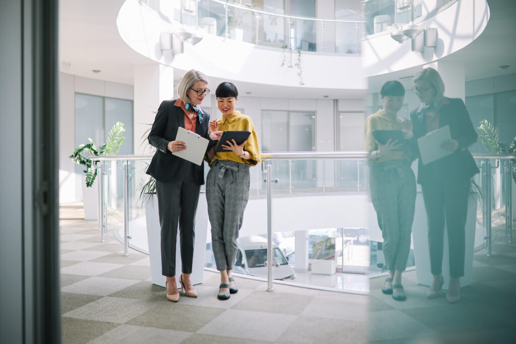 Two female colleagues interacting in the modern office. 