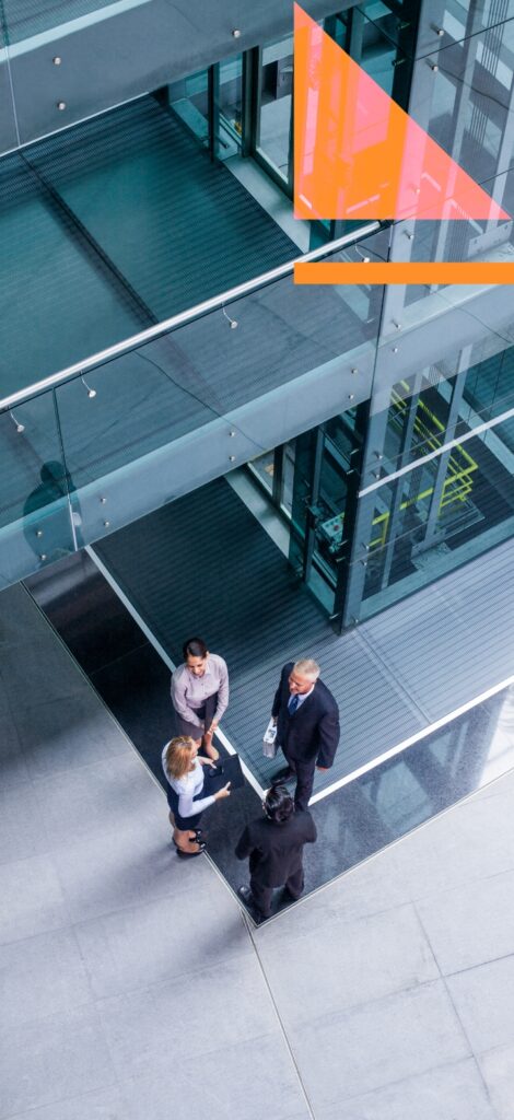 Three business people discuss roadmaps for IBP standing outside an office.